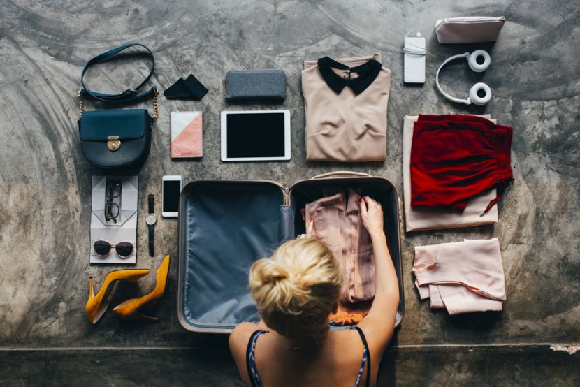 Woman packing clothes into a suitcase.