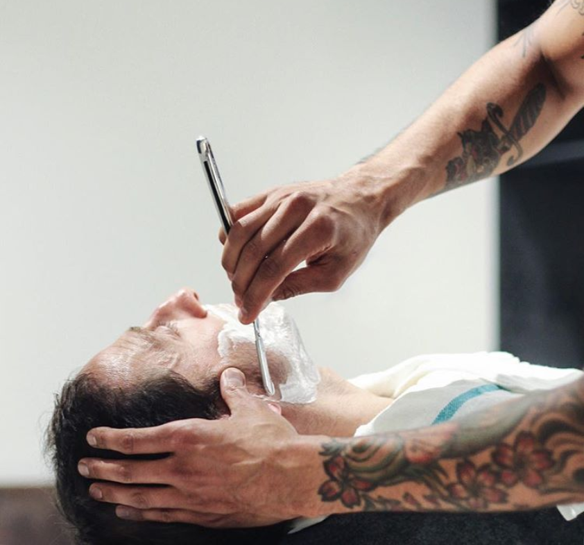 man being shaved with straight razor